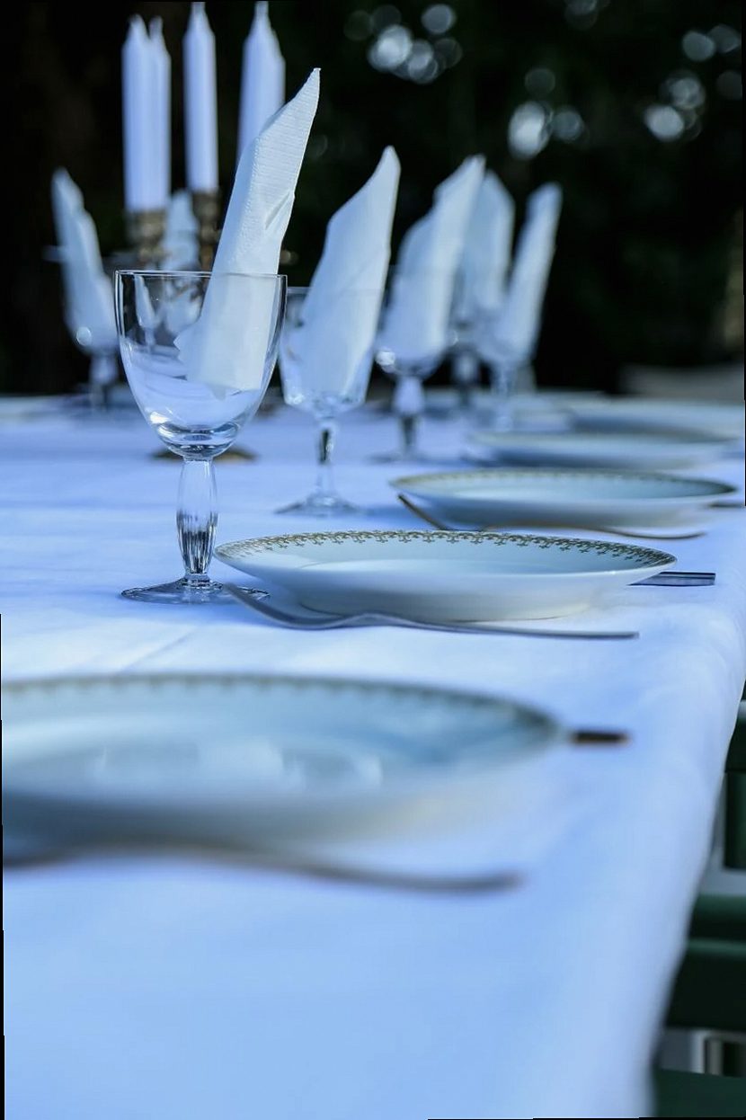 An elegant outdoor dining setup with fine glassware and candle lighting.